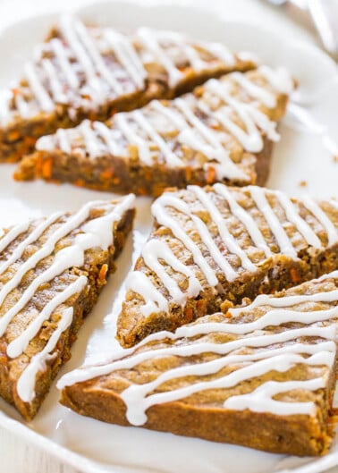 Slices of carrot cake with white icing drizzle on a plate.