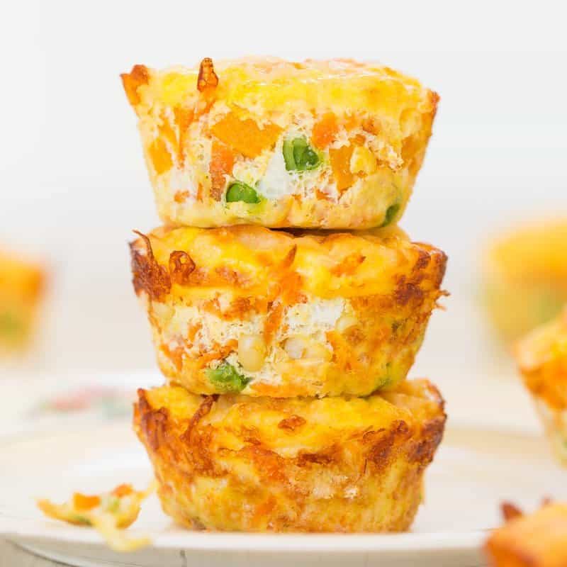 Stack of three savory breakfast egg muffins on a white plate.