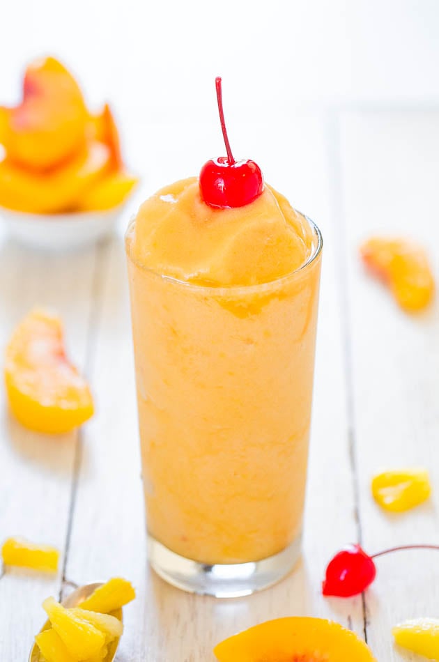 tropical drink with vodka in a glass surrounded by pieces of frozen fruit