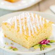 A slice of lemon drizzle cake on a floral plate.