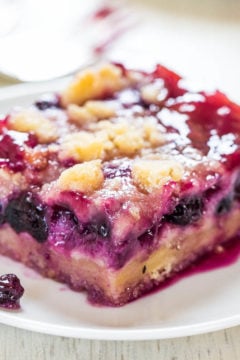 A slice of berry cobbler on a white plate.
