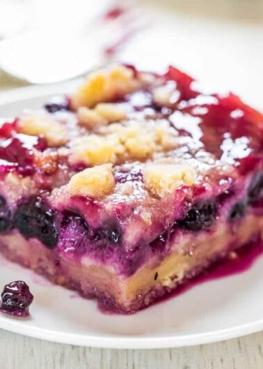 A slice of berry cobbler on a white plate.
