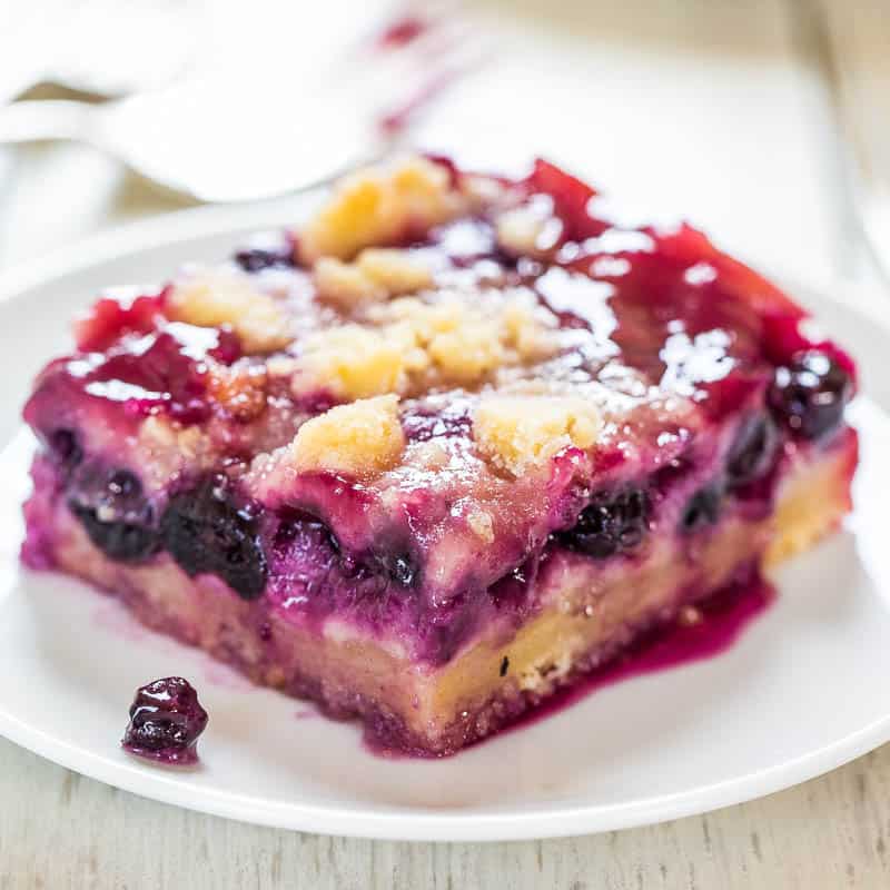A slice of berry cobbler on a white plate.
