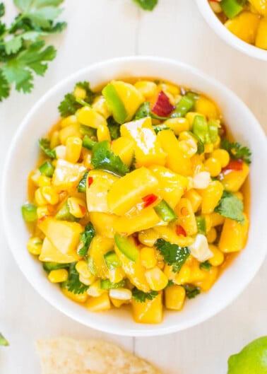 A bowl of corn and avocado salad garnished with cilantro.