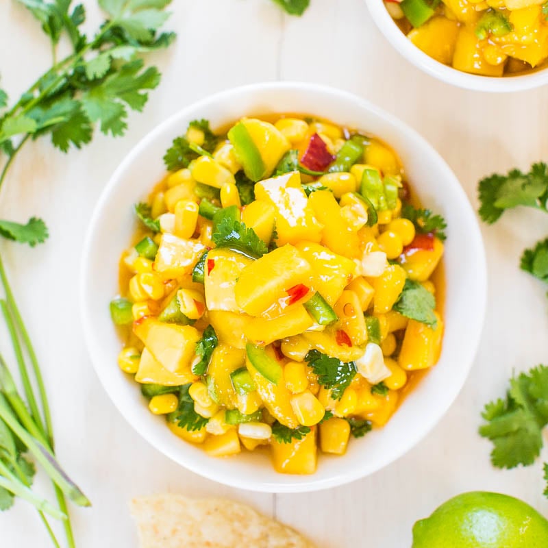 A bowl of corn and avocado salad garnished with cilantro.