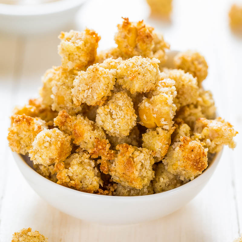 A bowl of crispy breaded cauliflower bites on a wooden surface.