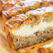 Slices of banana bread with a creamy filling on a wooden board.