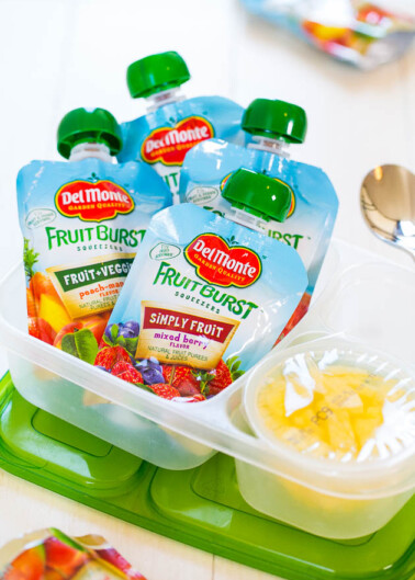 Assorted del monte fruit burst squeezers on a tray with spoons.