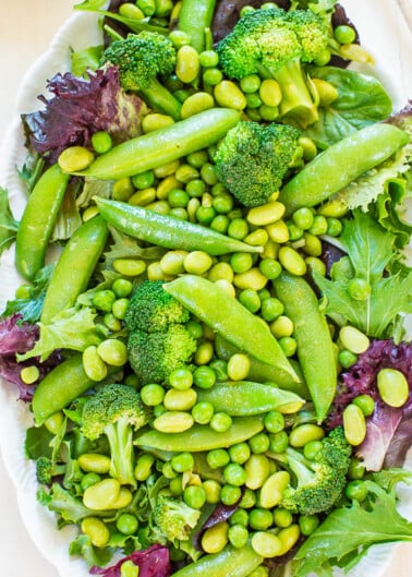 A fresh green salad with various vegetables including broccoli, peas, and leafy greens.