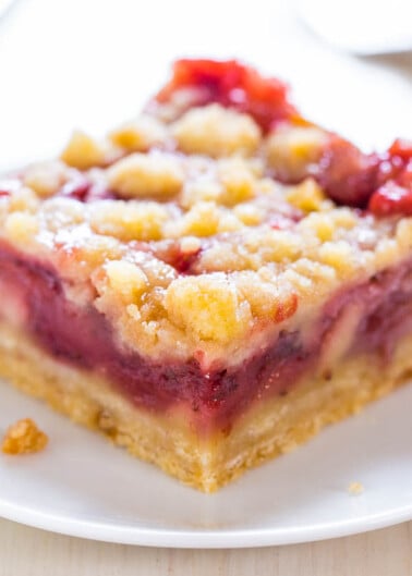 A piece of fruit crumble cake on a white plate.