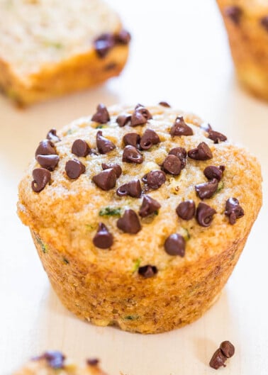 A chocolate chip muffin on a wooden surface.