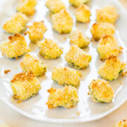 Baked breaded avocado bites arranged on a plate.