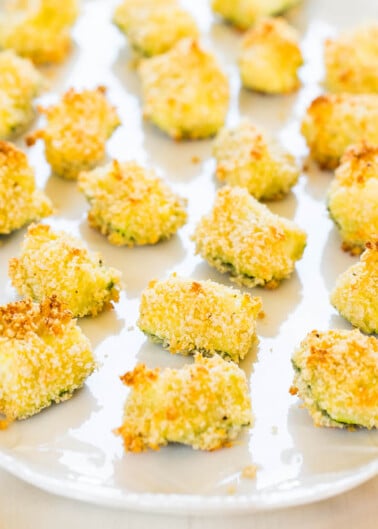 Baked breaded avocado bites arranged on a plate.