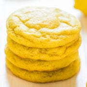 Stack of four lemon cookies on a wooden surface.