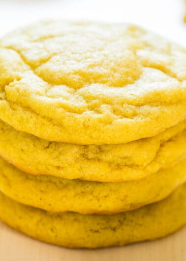 Stack of lemon cookies on a wooden surface.