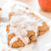 A freshly glazed scone on a white plate.