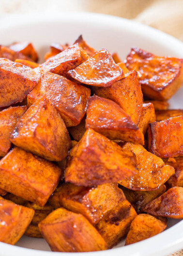 A bowl of roasted sweet potatoes seasoned with spices.