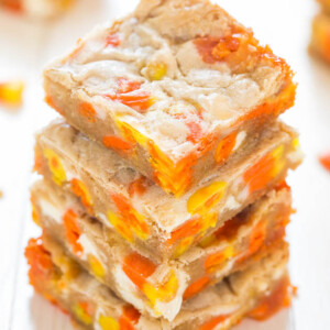 A stack of blondies with candy corn pieces on a wooden surface.