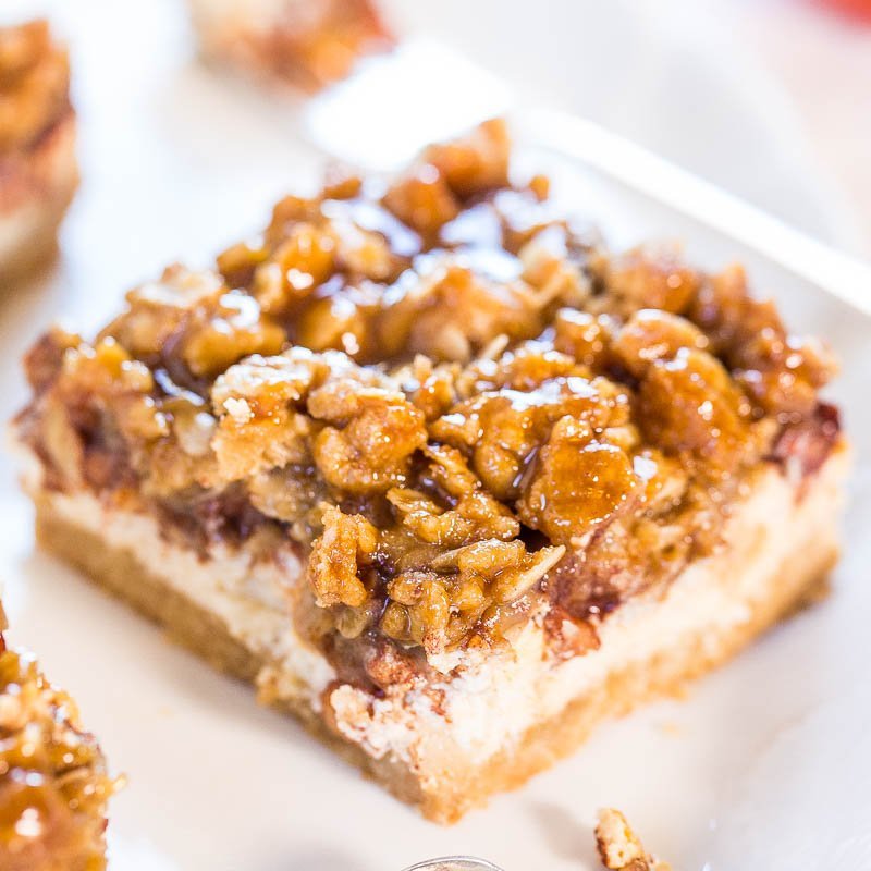 A close-up of a pecan pie bar on a white plate.