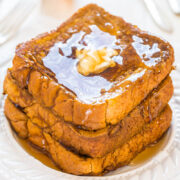 A stack of french toast with syrup and butter on top.