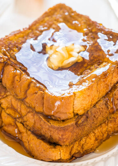 A stack of french toast with syrup and butter on top.