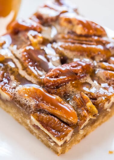 A close-up of a pecan bar with caramel topping and sea salt flakes.