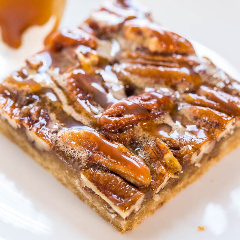 A close-up of a pecan bar with caramel topping and sea salt flakes.