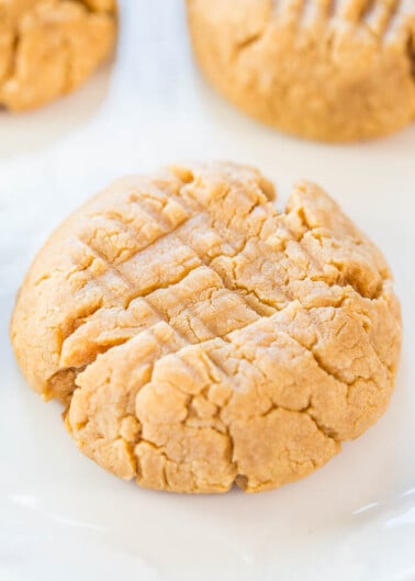 Freshly baked peanut butter cookie on a white plate.