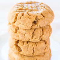 A stack of freshly baked peanut butter cookies on a white plate.