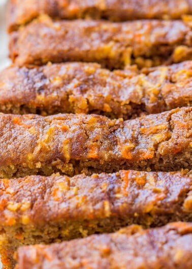 Slices of freshly baked carrot cake bread on a white surface.