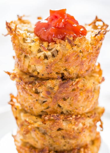 Stack of crispy hash browns topped with a dollop of ketchup.
