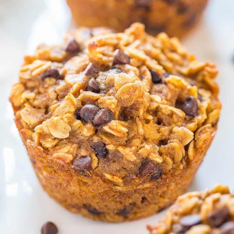 Close-up of an oatmeal chocolate chip muffin on a white surface.
