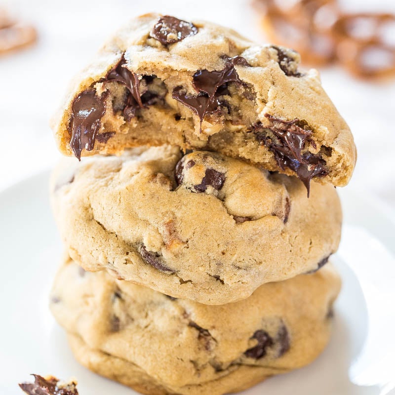 A stack of freshly-baked chocolate chip cookies with melty chocolate visible.
