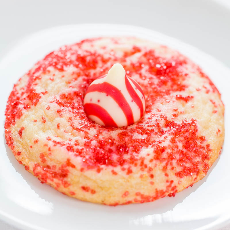 A red and white frosted cookie on a plate.
