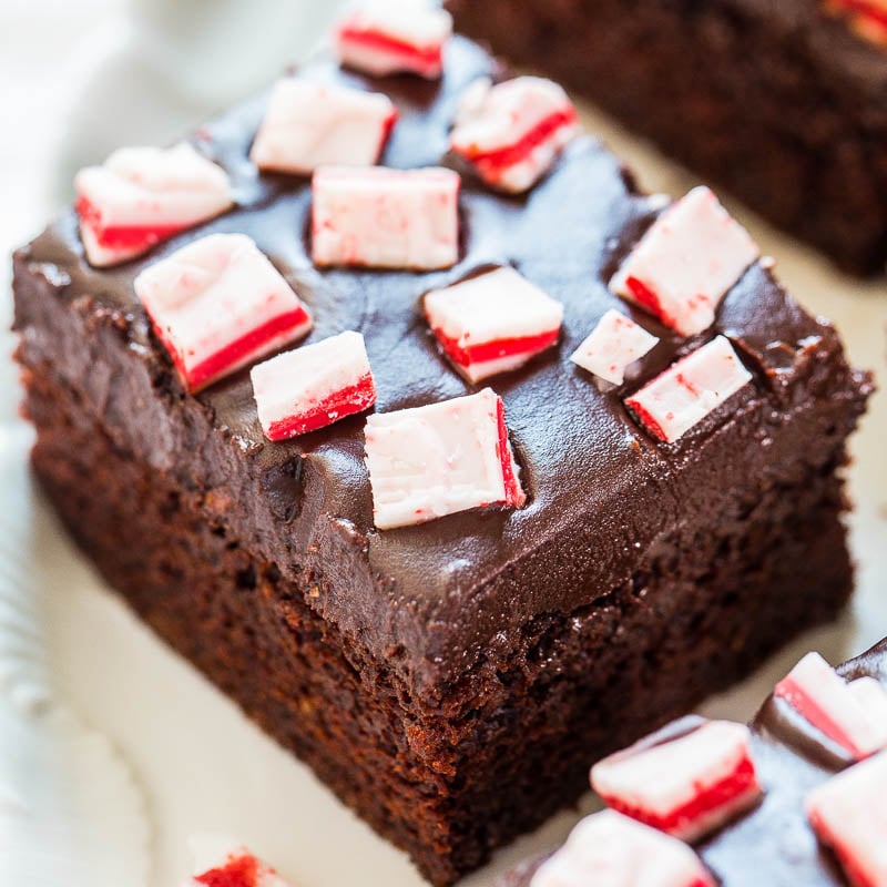 A close-up of a chocolate brownie topped with pieces of peppermint candy.