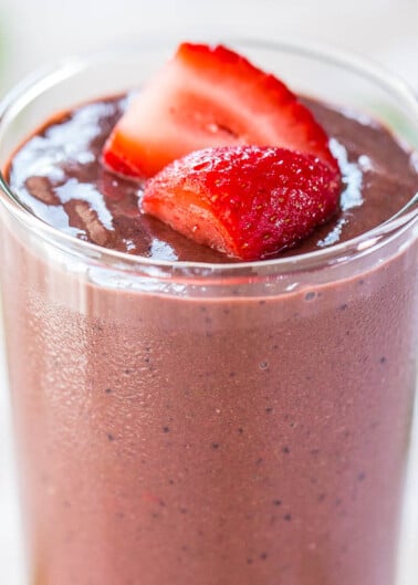 A strawberry-topped chocolate smoothie in a glass.