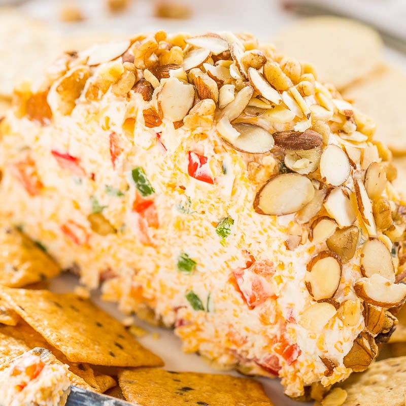 A cheese ball coated with sliced almonds, served with crackers on the side.