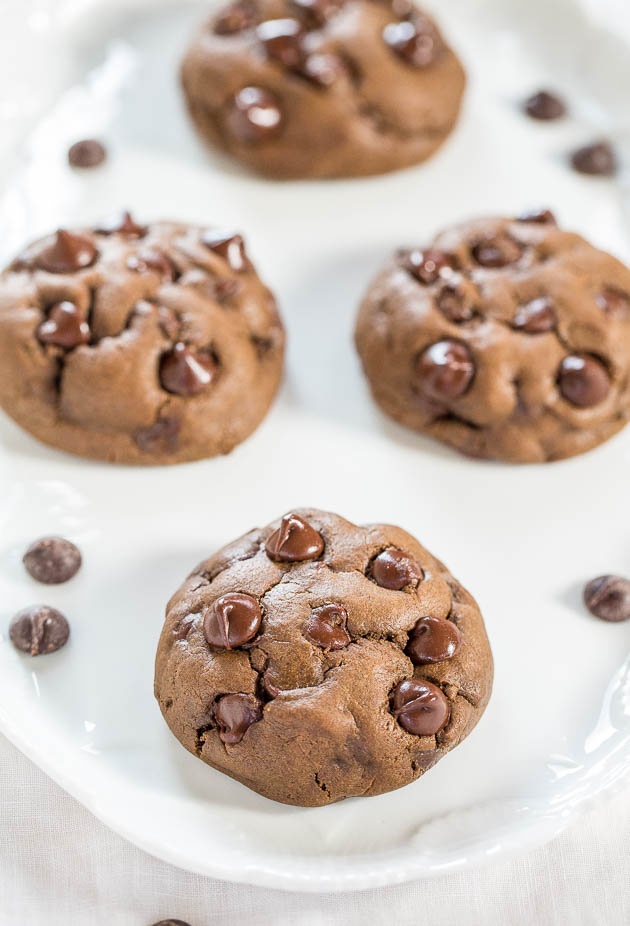 four chocolate chocolate chip cookies on white plate
