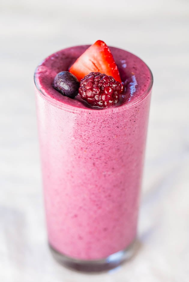 frozen fruit smoothie in glass topped with berries