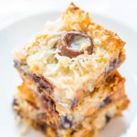 A stack of coconut macaroons with chocolate chips on a white plate.