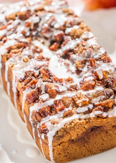 Glazed pecan-topped loaf on a white plate.