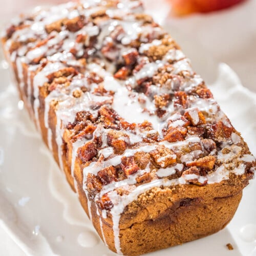 Glazed pecan-topped loaf on a white plate.