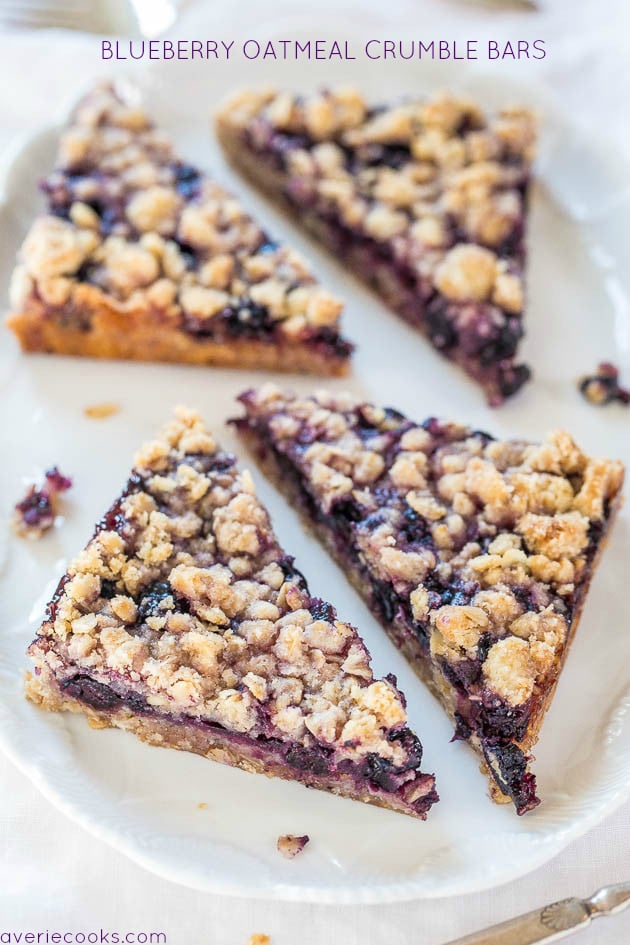 four blueberry bars with oatmeal crumble topping on white plate
