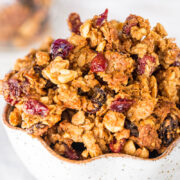 A bowl of granola with dried cranberries.