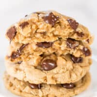 A stack of chocolate chip cookies on a white plate.