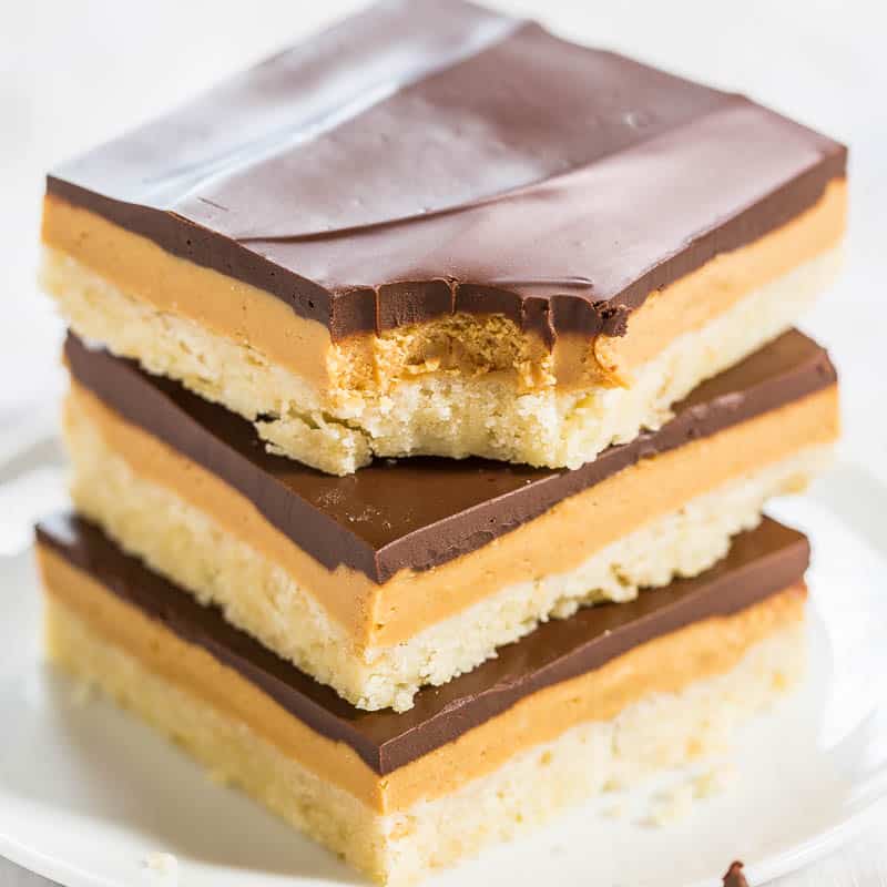Stack of layered dessert bars with chocolate topping.