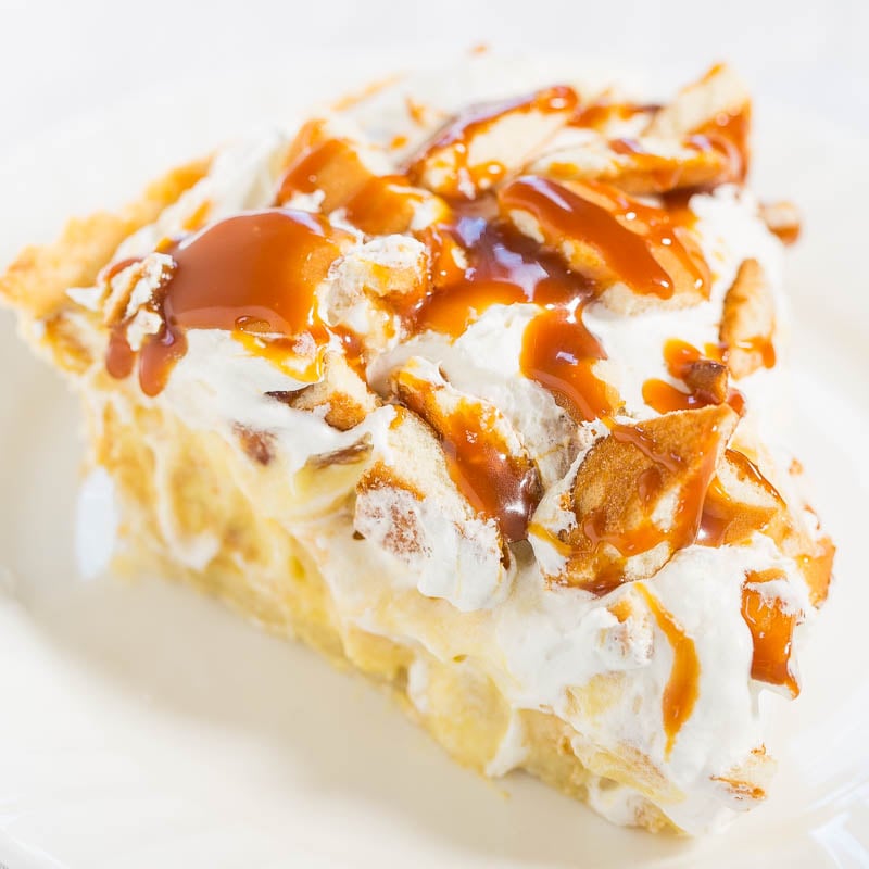 A slice of apple pie topped with whipped cream and caramel sauce.