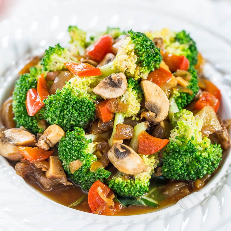 A plate of stir-fried mixed vegetables with broccoli, mushrooms, and peppers.