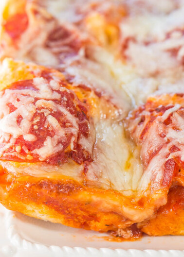 A close-up of a slice of pepperoni pizza with melted cheese.