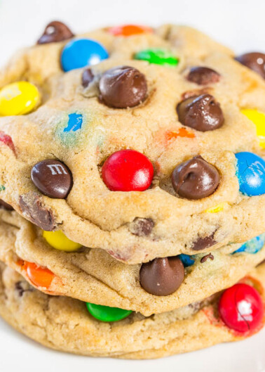 A stack of homemade chocolate chip cookies with colorful candy pieces.